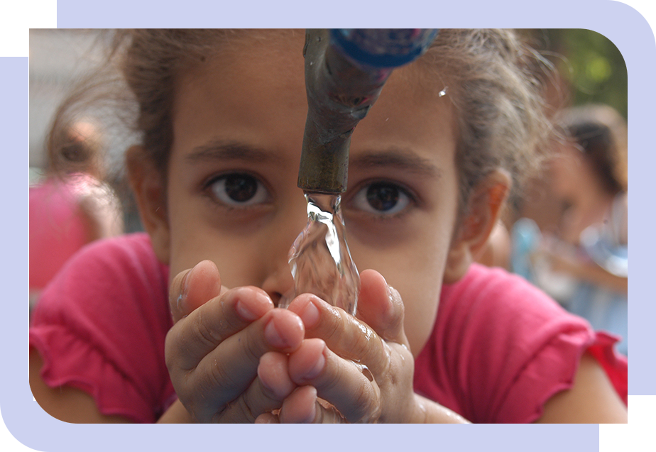 Fotografia de menina bebendo água da torneira com as mãos.