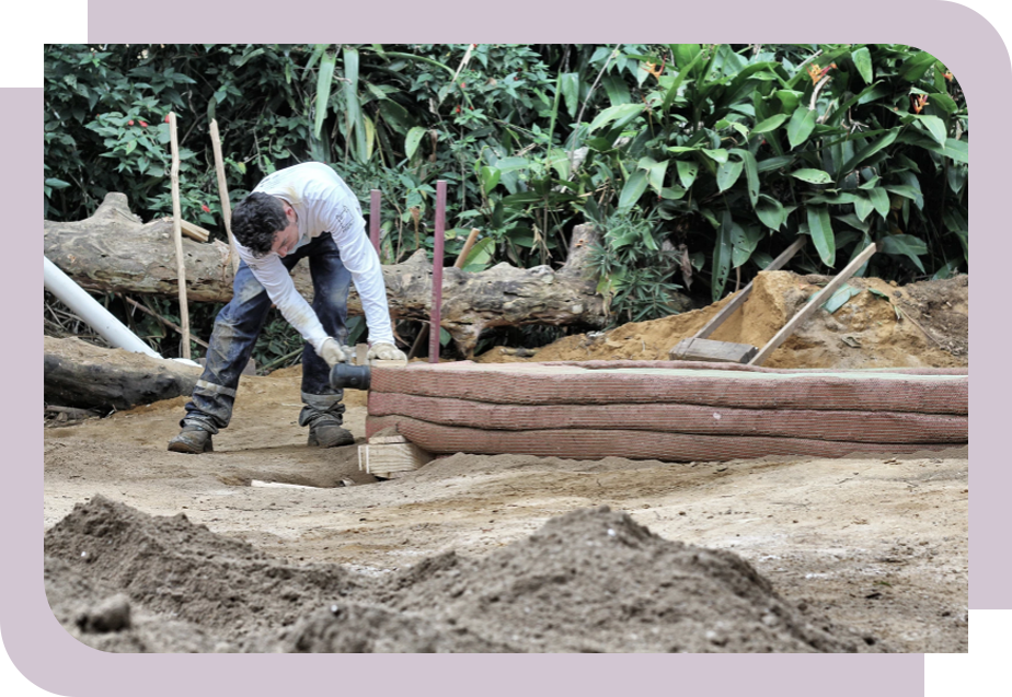 Foto de homem em um terreno arenoso manipulando uma ferramenta para construção do TVAP.